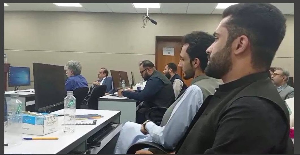 Bilal Ahmad and workshop participants collaborating at computers at the HEC event